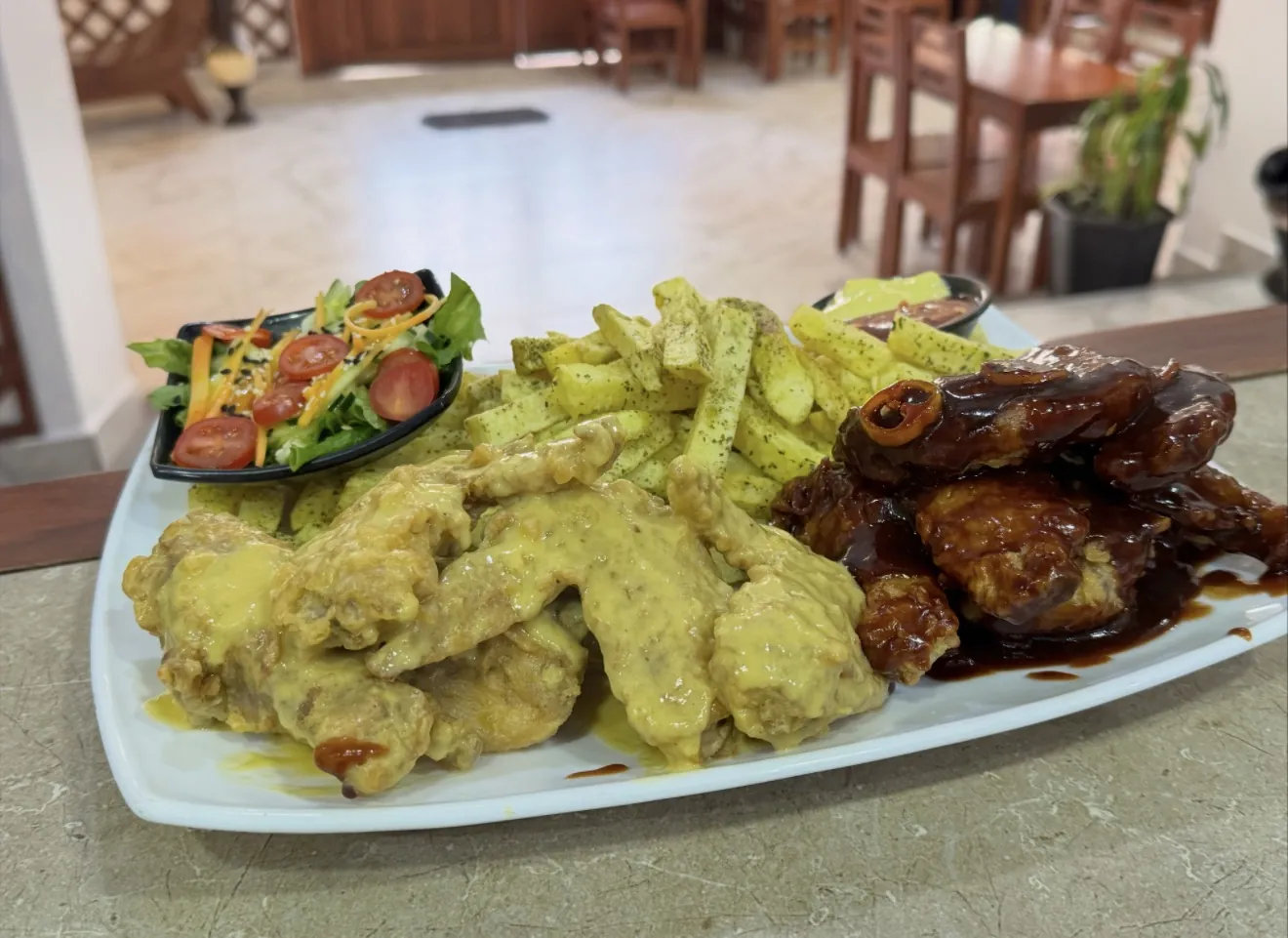 Alitas en salsa BBQ y en salsa de maracuyá, con papas y ensalada