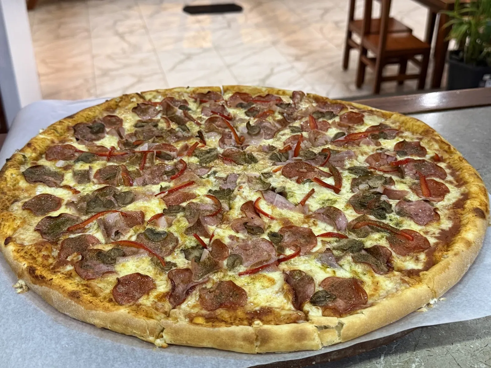 Pizza grande con peperoni, salami, jamón, champiñones y pimiento
