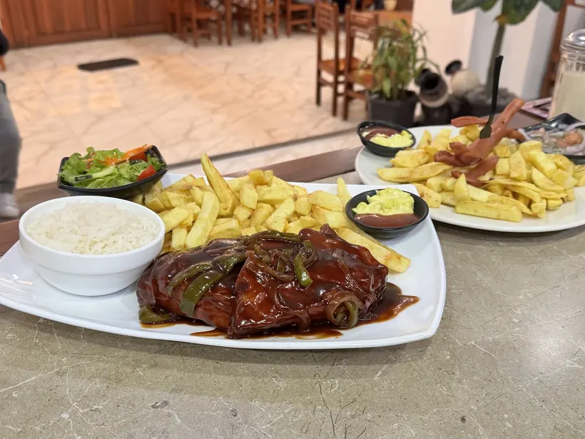 Plato en salsa BBQ con papas, arroz y ensalada