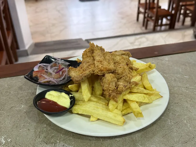Papipollo: pollo apanado con papas fritas y curtido